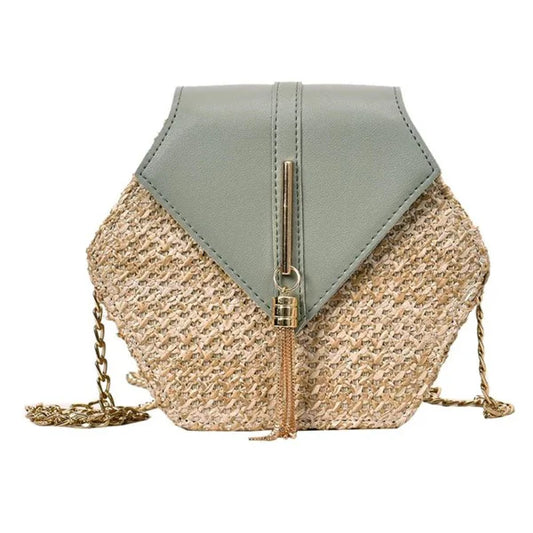 Woven straw crossbody bag with green flap and tassel detail on white background