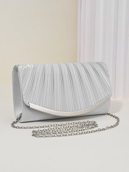 Pleated metallic clutch held by model showing slim structured silhouette, women’s elegant evening handbag with detachable chain strap