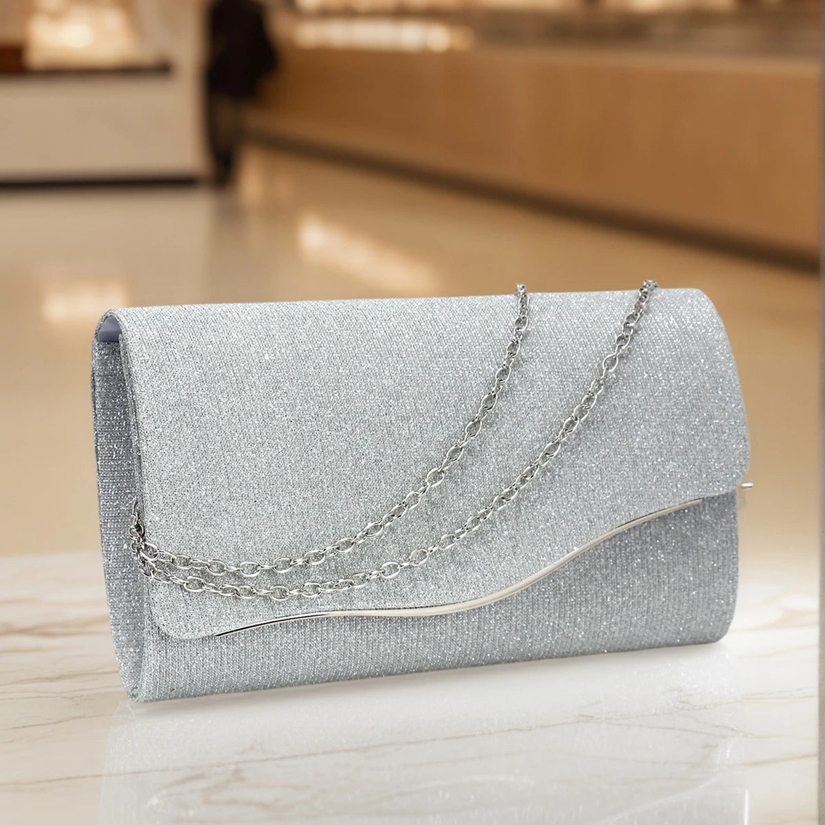 Sparkling envelope evening clutch showing structured silhouette and chain strap detail, women’s formal party handbag in black glitter finish
