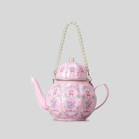 Pink teapot shaped novelty handbag with floral design and gold chain strap, whimsical women’s statement shoulder bag