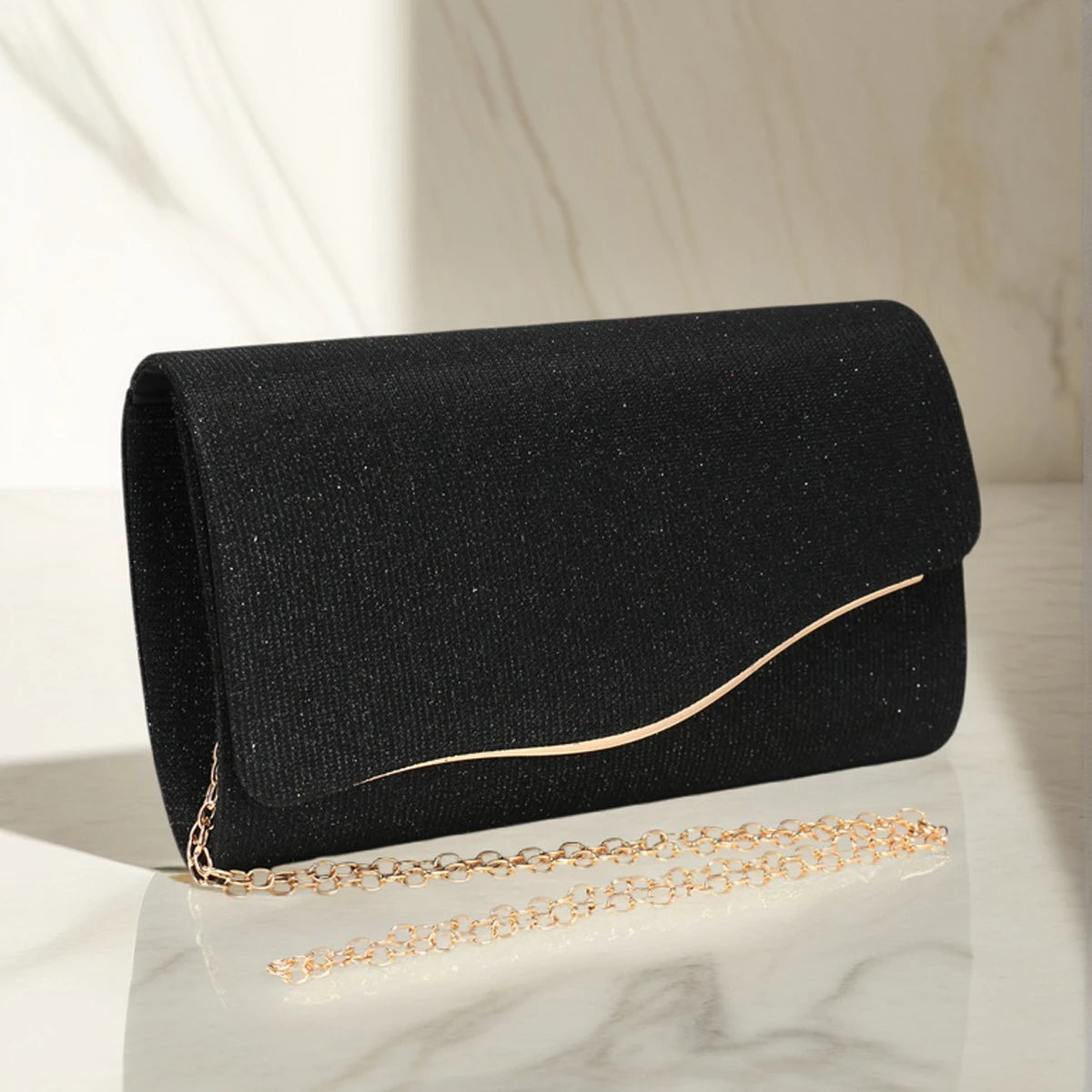 Black glitter envelope clutch with gold chain strap and curved metallic accent, elegant women’s evening handbag for parties and formal events