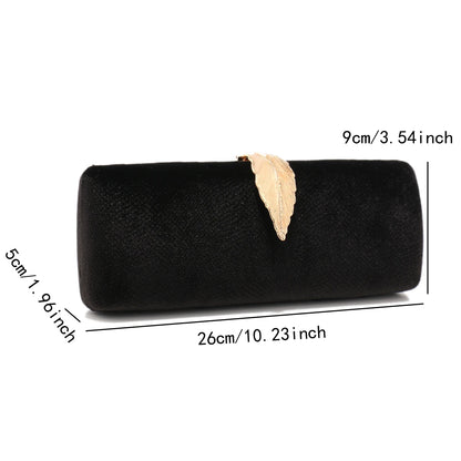 Structured velvet flap clutch with metallic leaf detail held in hand, luxury women’s evening purse with chain strap